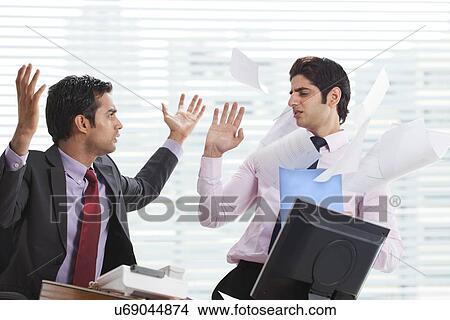 Picture - Displeased businessman throwing papers on executive . Fotosearch