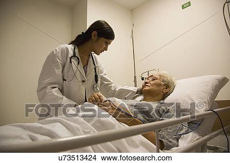 Picture - Doctor checking on her patient . Fotosearch