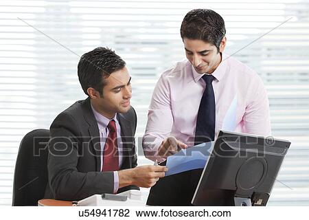 Stock Image - Executives working on new business plan . Fotosearch