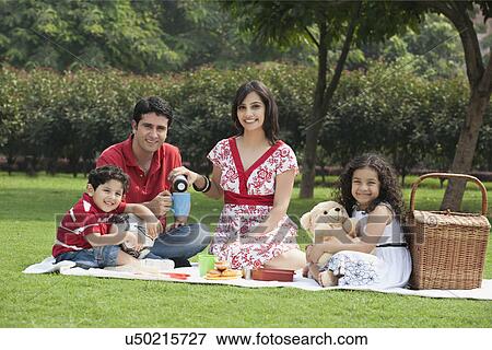 Family enjoying at a picnic View Large Photo Image Stock Photo - Family enjoying at a picnic . Fotosearch