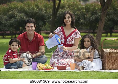 Family enjoying at a picnic View Large Photo Image Stock Photo - Family enjoying at a picnic . Fotosearch