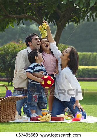 Stock Image - Family enjoying themselves at a picnic . Fotosearch