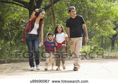 Stock Photo - Family going for a walk in a park . Fotosearch
