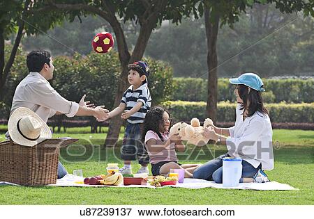 Stock Photo - Family having fun at a picnic . Fotosearch