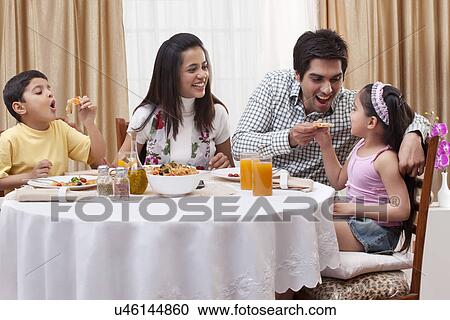Family having fun while eating pizza together at restaurant View Large Photo Image Stock Image - Family having fun while eating pizza together at restaurant . Fotosearch