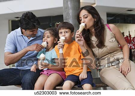 Stock Image - Family having great time together while eating ice cream . Fotosearch