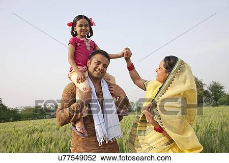 Family in field with girl on father's shoulders View Large Photo Image Stock Image - Family in field with girl on father's shoulders . Fotosearch