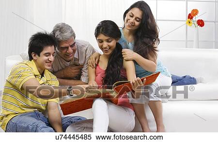 Family looking at the family album View Large Photo Image Stock Photography - Family looking at the family album . Fotosearch