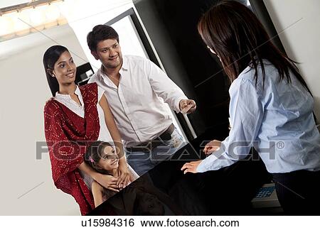Stock Photograph - Family making a purchase at a counter . Fotosearch