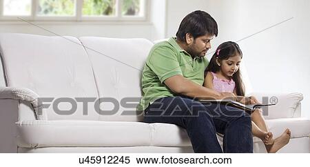 Stock Photography - Father and daughter reading a book . Fotosearch
