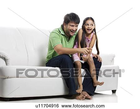 Father and daughter watching television View Large Photo Image Stock Photograph - Father and daughter watching television . Fotosearch