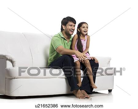 Stock Photograph - Father and daughter watching television . Fotosearch