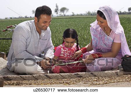 Stock Photo - Father and mother assisting daughter with her homework . Fotosearch