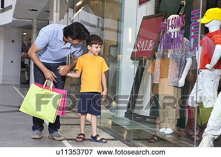 Father and son out for shopping in a mall View Large Photo Image Stock Photo - Father and son out for shopping in a mall . Fotosearch