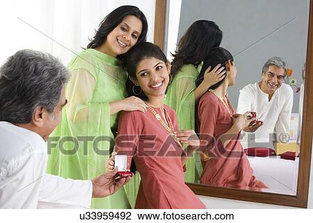 Stock Image - Father giving a ring to his daughter . Fotosearch