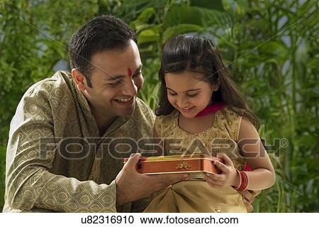 Father giving his daughter chocolates View Large Photo Image Stock Image - Father giving his daughter chocolates . Fotosearch