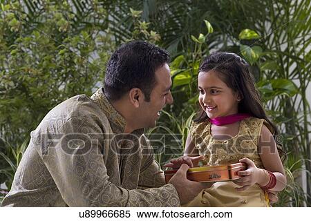 Father giving his daughter chocolates View Large Photo Image Stock Photography - Father giving his daughter chocolates . Fotosearch