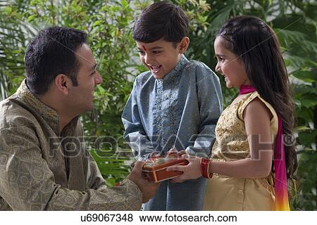 Father giving his kids chocolates View Large Photo Image Stock Photo - Father giving his kids chocolates . Fotosearch