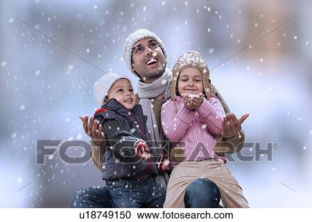 Father sitting with kids as it snows View Large Photo Image Stock Image - Father sitting with kids as it snows . Fotosearch