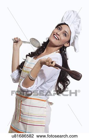 Stock Image - Female chef with cooking utensils. Fotosearch