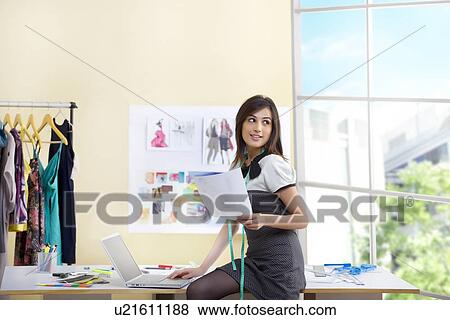 Female clothing designer using laptop in studio View Large Photo Image Stock Photo - Female clothing designer using laptop in studio . Fotosearch