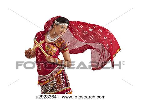 Female dandiya dancer dancing with sticks View Large Photo Image Stock Image - Female dandiya dancer dancing with sticks . Fotosearch