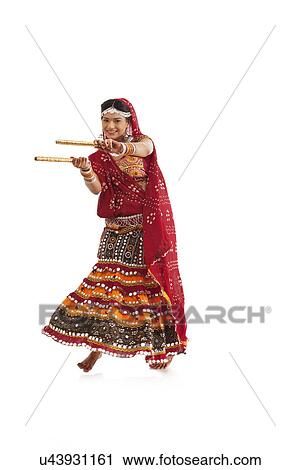Female dandiya dancer dancing with sticks View Large Photo Image Stock Image - Female dandiya dancer dancing with sticks . Fotosearch