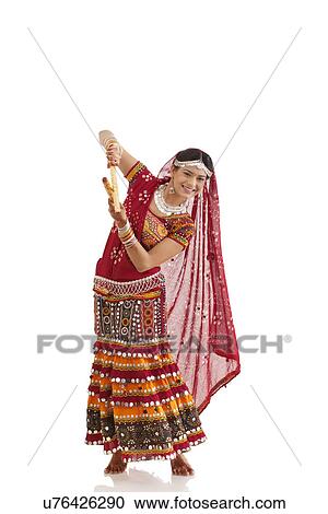 Stock Image - Female dandiya dancer dancing with sticks . Fotosearch
