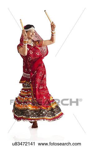 Female dandiya dancer dancing with sticks View Large Photo Image Stock Image - Female dandiya dancer dancing with sticks . Fotosearch