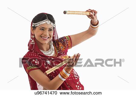 Female dandiya dancer dancing with sticks View Large Photo Image Stock Image - Female dandiya dancer dancing with sticks . Fotosearch