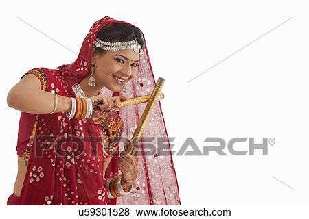 Stock Photo - Female dandiya dancer dancing with sticks . Fotosearch