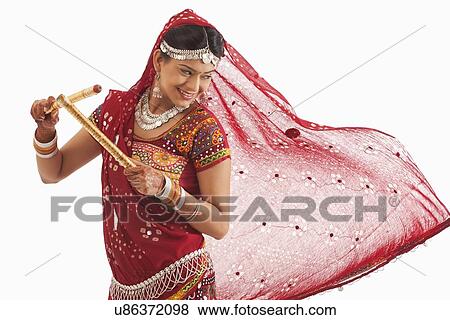 Female dandiya dancer dancing with sticks View Large Photo Image Stock Photo - Female dandiya dancer dancing with sticks . Fotosearch