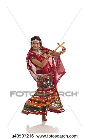 Stock Photograph - Female dandiya dancer dancing with sticks . Fotosearch