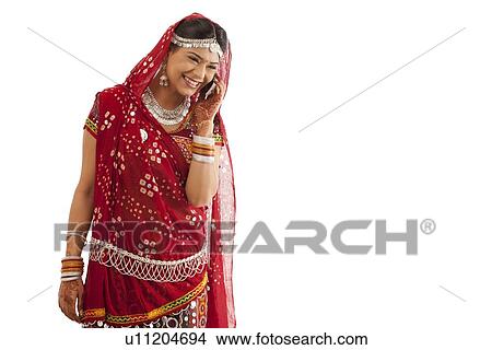 Female dandiya dancer talking on a mobile phone View Large Photo Image Picture - Female dandiya dancer talking on a mobile phone . Fotosearch