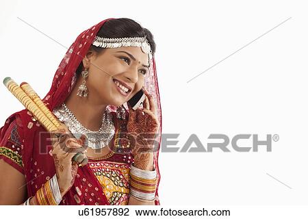 Stock Image - Female dandiya dancer talking on a mobile phone . Fotosearch