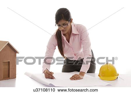Stock Image - Female engineer making blueprints . Fotosearch