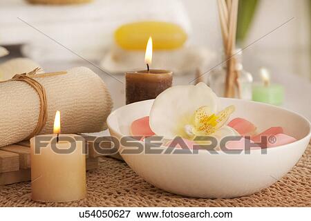 Stock Photo - Flowers in a bowl with candles and bath scrub . Fotosearch