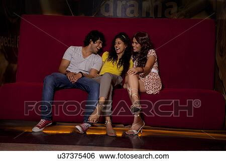 Friends enjoying at movie theatre together View Large Photo Image Stock Photograph - Friends enjoying at movie theatre together . Fotosearch