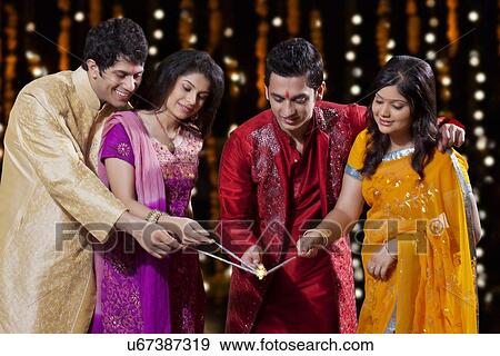 Stock Photo - Friends lighting a sparkler. Fotosearch