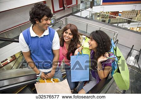 Stock Photo - Friends shopping at mall together . Fotosearch