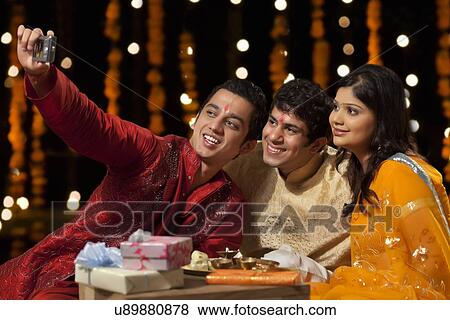 Stock Photo - Friends with camera taking a self portrait. Fotosearch