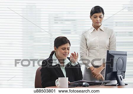 Frustrated businesswoman reading document with female executive View Large Photo Image Stock Image - Frustrated businesswoman reading document with female executive . Fotosearch