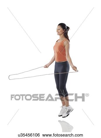 Full length of a fitness woman exercising with jump rope over white background View Large Photo Image Stock Photograph - Full length of a fitness woman exercising with jump rope over white background . Fotosearch