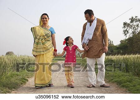 Full length of an Indian family walking on a rural road  View Large Photo Image Stock Image - Full length of an Indian family walking on a rural road . Fotosearch