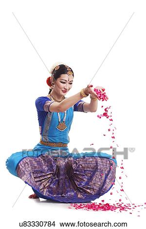 Picture - Full length of Bharatanatyam dancer dropping rose petals over white background. Fotosearch