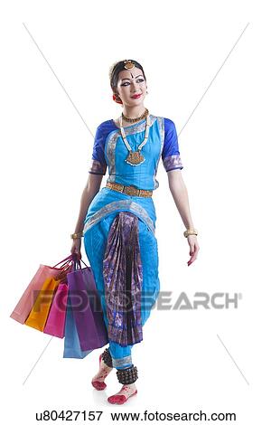 Full length of Bharatanatyam dancer carrying shopping bags over white background View Large Photo Image Stock Photo - Full length of Bharatanatyam dancer carrying shopping bags over white background. Fotosearch