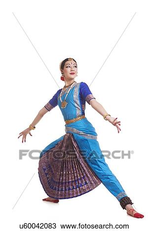 Stock Image - Full length of dancer in traditional wear performing Bharatanatyam against white background. Fotosearch