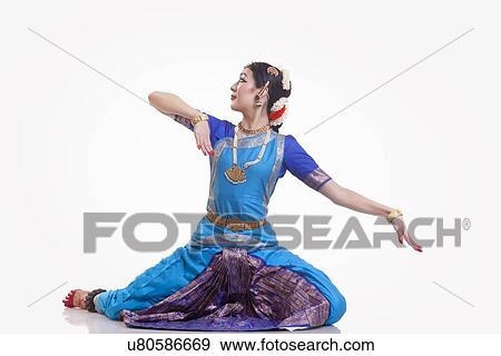 Stock Photo - Full length of dancer in traditional wear performing Bharatanatyam against white background. Fotosearch