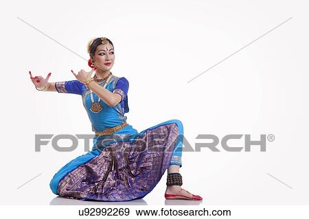 Stock Photo - Full length of female dancer performing Bharatanatyam against white background. Fotosearch