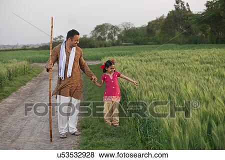 Full length of little girl with her father in a wheat field View Large Photo Image Stock Photo - Full length of little girl with her father in a wheat field . Fotosearch